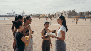 Grupo de deportistas recibiendo consejos de nutrición durante una jornada de entrenamiento en la playa