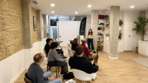 Profesional impartiendo una charla sobre nutrición, bienestar y rendimiento ante un grupo de participantes en un espacio moderno