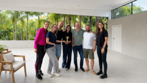 Grupo de participantes celebrando una actividad de nutrición y bienestar en un espacio luminoso rodeado de vegetación