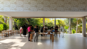 Grupo de participantes preparando recetas saludables durante un taller de cocina en un espacio abierto con vistas al jardín